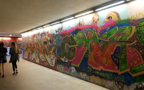 a wall covered in graffiti in a tunnel at Vilnius apartment with stained glass in Vilnius