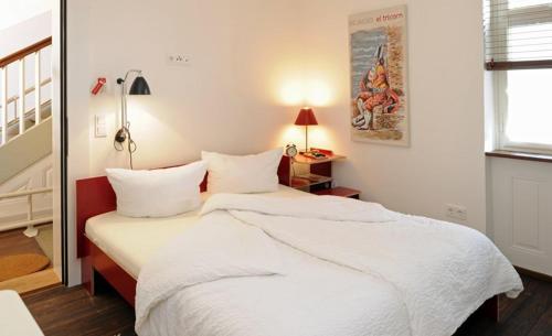 a bedroom with a large bed with white sheets at Gasthaus Schwanen & Villa Pfarrhus in Stühlingen