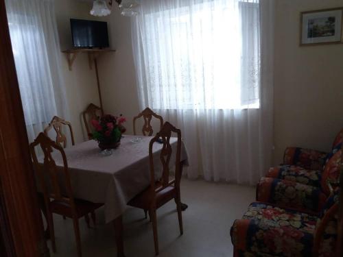 jadalnia ze stołem i krzesłami oraz oknem w obiekcie Se alquila piso en Sanxenxo con vistas al mar w mieście Sanxenxo