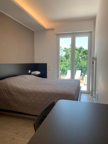 Un dormitorio con una cama y una ventana grande. en Il parco di Yuki (5), en Ancona