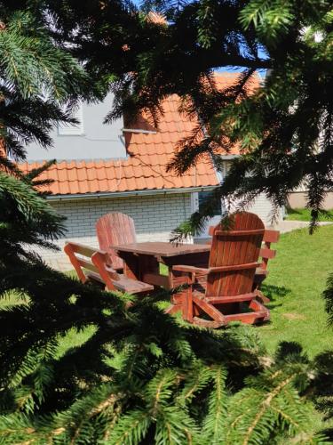 two chairs and a wooden table with a table and two chairs at Home Belić Golija in Radaljica