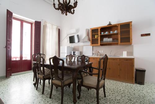 a dining room with a table and chairs and a kitchen at Chez Georges in Parikia