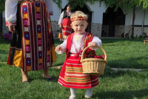 a little girl in a dress holding a basket at Osmarski Houses in Osmar