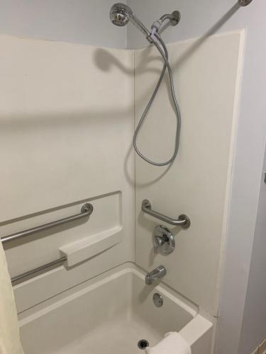 a shower in a hotel bathroom with a sink at Key West Inn - Childersburg in Childersburg