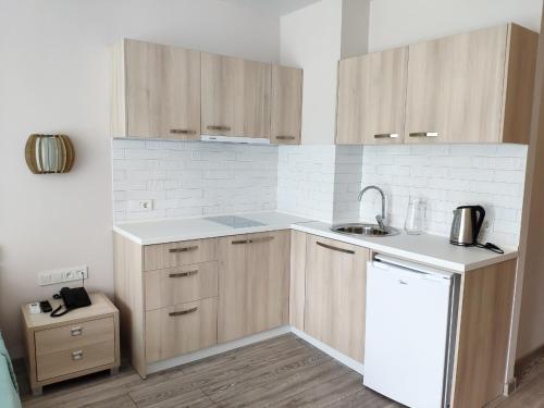 a kitchen with wooden cabinets and a sink at Green Line in Mtsvane Kontskhi