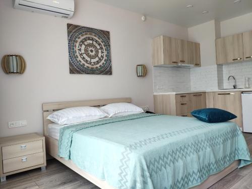 a bedroom with a large bed and a kitchen at Green Line in Mtsvane Kontskhi