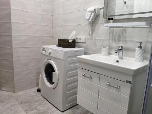 a white bathroom with a washing machine and a sink at Green Line in Mtsvane Kontskhi