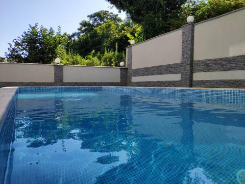 a swimming pool with blue water in front of a fence at Green Line in Mtsvane Kontskhi