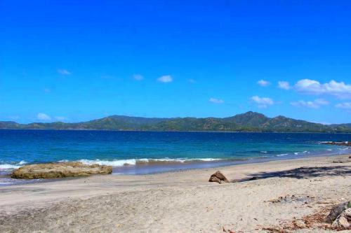 a beach with the ocean and mountains in the background at Flamingo Marina Hotel in Playa Flamingo