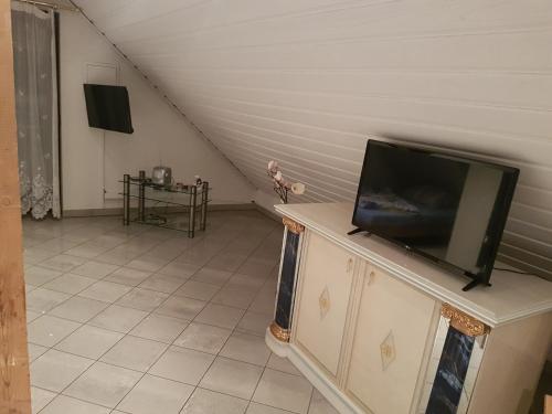 a living room with a flat screen tv on a dresser at Gino s Ferienwohnung in Illingen