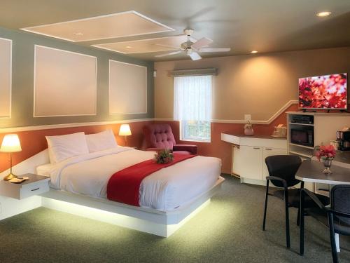 Motel La Cheminée في سان جيروميه: غرفة نوم بسرير كبير وتلفزيون