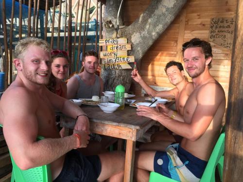 a group of men sitting around a wooden table at Raw KokoMar PosadaNativa in Baru