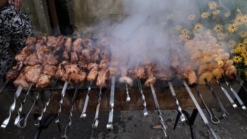 um monte de carne numa grelha com pinças em Cottage Teremok 7 people em Ureki