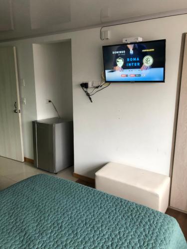 1 dormitorio con 1 cama y TV de pantalla plana en Aparta estudio en norte, en Bogotá