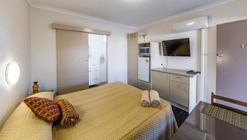 a hotel room with a bed and a television at Kingaroy Country Motel in Kingaroy