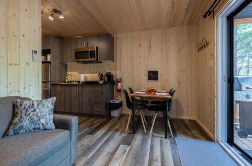 a living room with a table in a tiny house at Motel and Camping Colibri in Caraquet