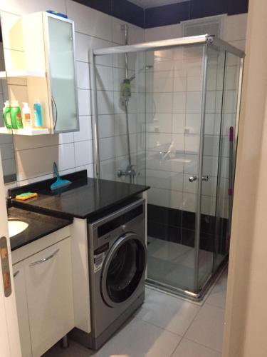 een badkamer met een douche en een wasmachine bij Apartment in Avsallar