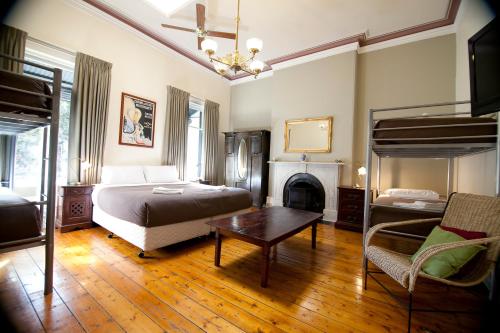 1 dormitorio con 1 cama, chimenea y mesa en The Nunnery Accommodation en Melbourne