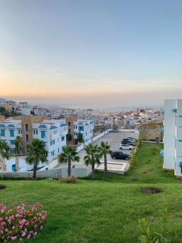 a view of a city with palm trees and buildings at Résidence Lilia Al Jabal M’diQ in M'diq