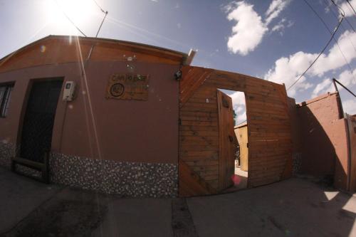a tiny house is shown with the sun behind it at Hostal Campo Base in San Pedro de Atacama