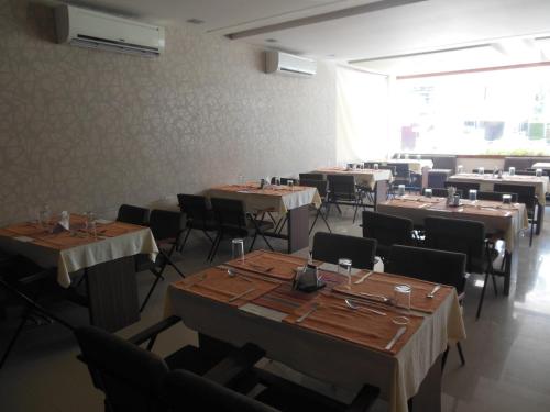 a dining room with tables and chairs and a large window at Sayoojyam Residency in Palakkad