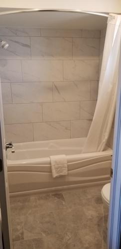 bagno con vasca e servizi igienici di Royal Napanee Inn a Napanee