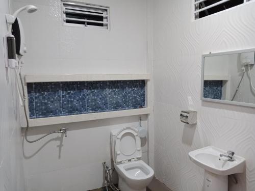 a white bathroom with a toilet and a sink at Jazepuri - Jaze 3 in Kuching