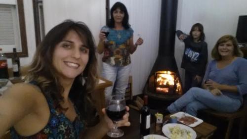 un grupo de mujeres sentadas alrededor de una mesa con una copa de vino en Chale de Madeira - Lareira e Fogueira---lindo gramado com mesa para café da manhã, churrasqueira e fogueira, en Campos do Jordão