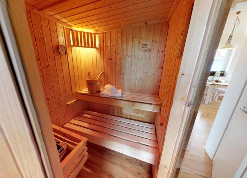 a wooden sauna with a bench in a room at Feriendorf Südstrand Haus 40 in Pelzerhaken