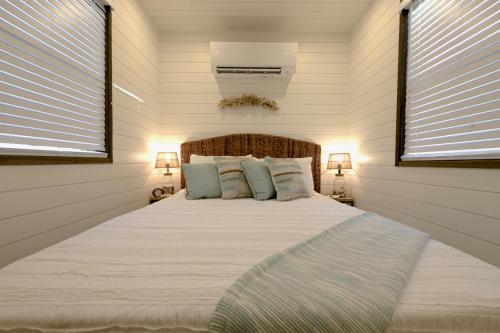 a bedroom with a large bed with two windows at The Shoreline Container Home 12 min to Magnolia Silos and Baylor in Waco