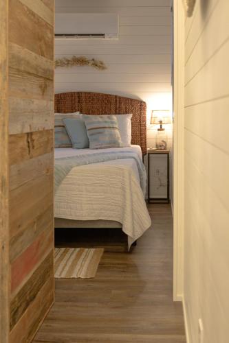 a bedroom with a bed with a wooden wall at The Shoreline Container Home 12 min to Magnolia Silos and Baylor in Waco