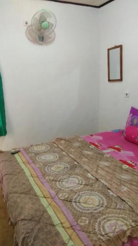 a bed in a corner of a room at ADELYA HOMESTAY in Praya