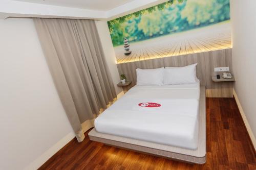 a white bed in a room with a painting on the wall at My Hotel @ KL Sentral in Kuala Lumpur