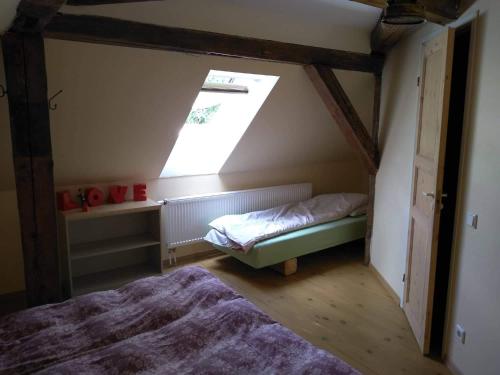 a attic room with a bed and a window at Torma Puhkemaja ja Glämping in Torma