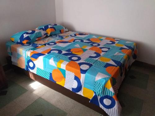 una cama con un edredón colorido en una habitación en Big House Medellin, en Medellín