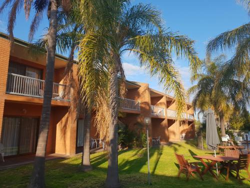 a building with palm trees in front of it at Crystal Fountain Motel Albury in Albury