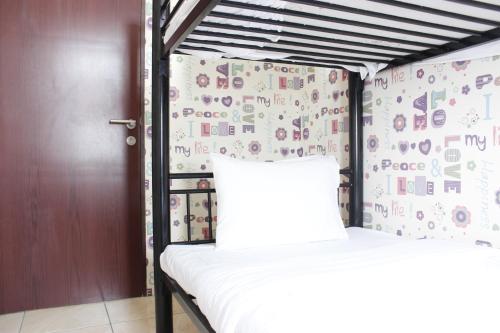 a bedroom with a bunk bed with a wall covered in stickers at Cozy 2BR Tamansari Panoramic Apartment By Travelio in Bandung