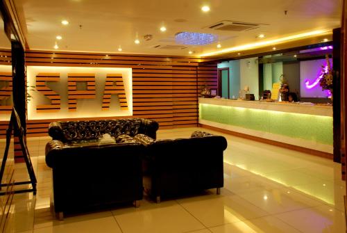 a living room with a couch and a bar at Berjaya Waterfront Hotel, Johor Bahru in Johor Bahru