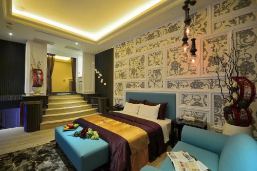 a bedroom with a bed and a couch and stairs at Hea Duenn Motel in Taichung