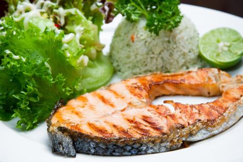 a plate of food with a piece of fish and a salad at Vabua Asotel Bangkok in Bangkok