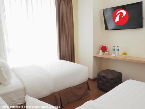 a hotel room with two beds and a television at d'primahotel Panakkukang Makassar (Formerly Fave Panakkukang) in Makassar