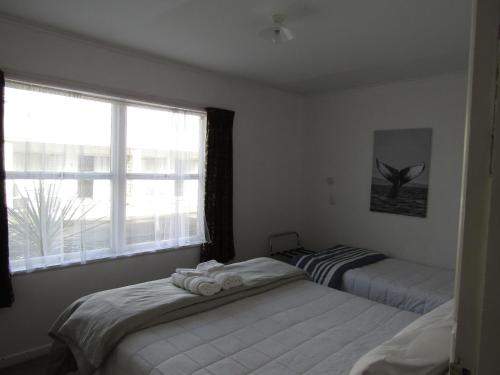 a bedroom with two beds and a window at Anchorage Motel in Whitianga