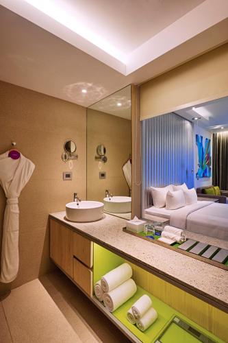 a bathroom with a sink and a large mirror at Avasa Hotel in Hyderabad