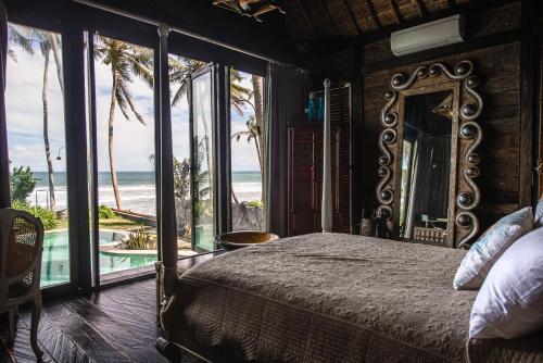 a bedroom with a bed and a view of the ocean at Tabanan Villas in Tabanan