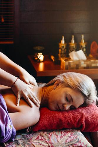 a woman laying on a pillow on a bed at Ari Putri Hotel in Sanur