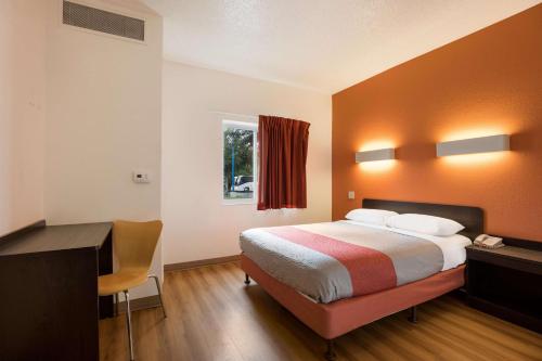 a hotel room with a bed and a desk at Motel 6-Orlando, FL - International Dr in Orlando