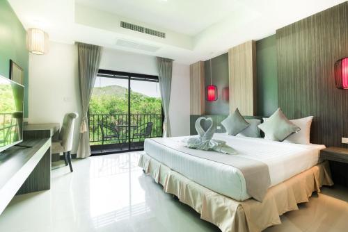 een slaapkamer met een groot bed en een balkon bij Prelude Hotel in Kanchanaburi