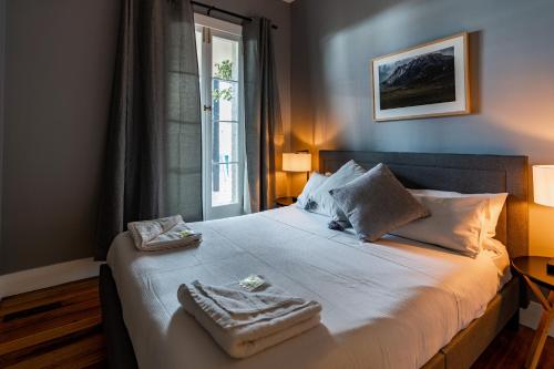 een slaapkamer met een bed met twee handdoeken erop bij The Tasmanian Inn in Hobart