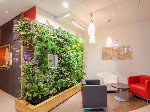 a large green wall in a waiting room at Ibis Sarlat Centre in Sarlat-la-Canéda