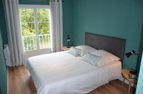 ein Schlafzimmer mit einem großen weißen Bett und einem Fenster in der Unterkunft Grand T2 Port de Vannes, vue sur jardin in Vannes